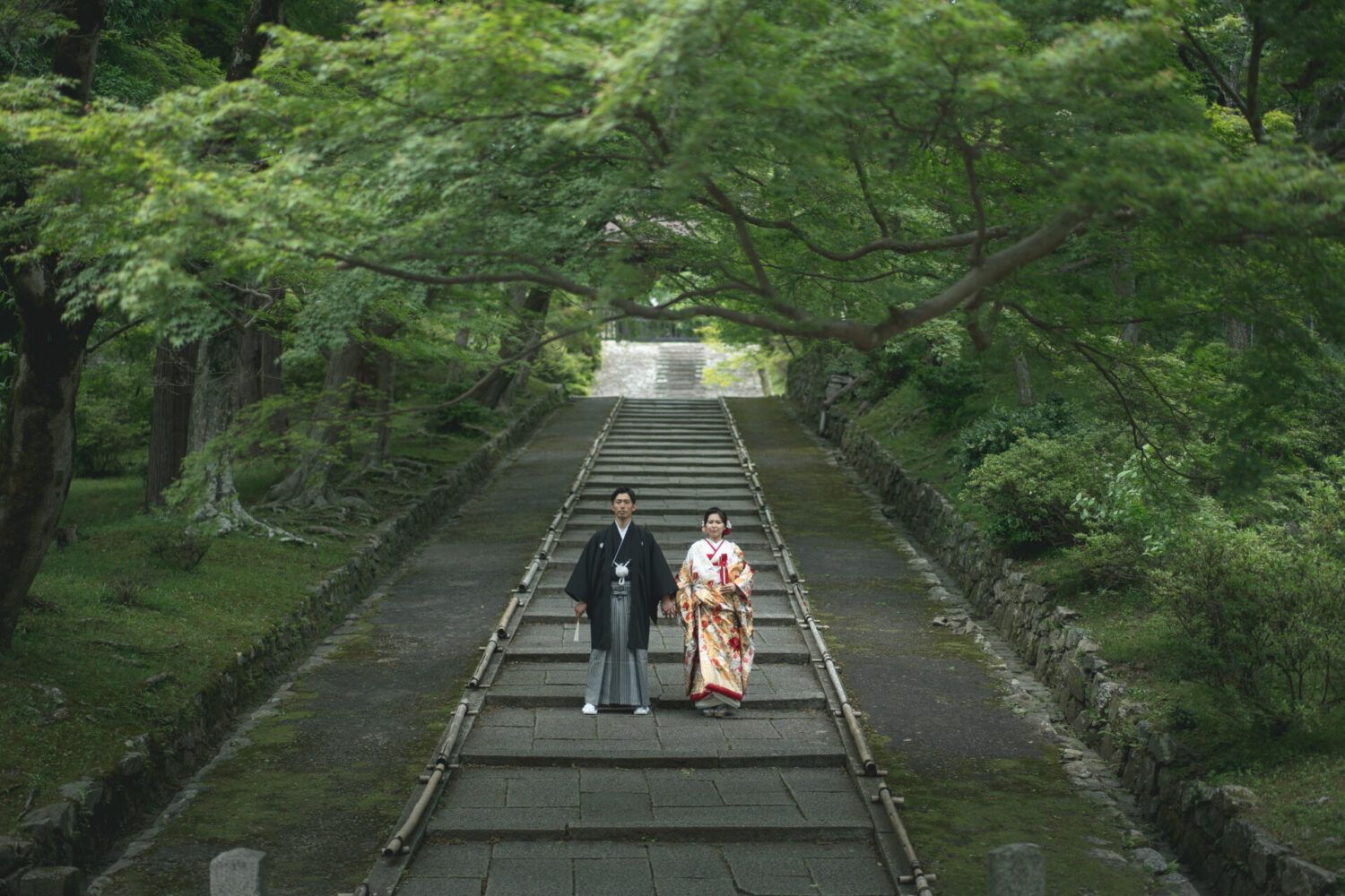 毘沙門堂の石畳の階段にて。色打掛の花嫁と新郎。