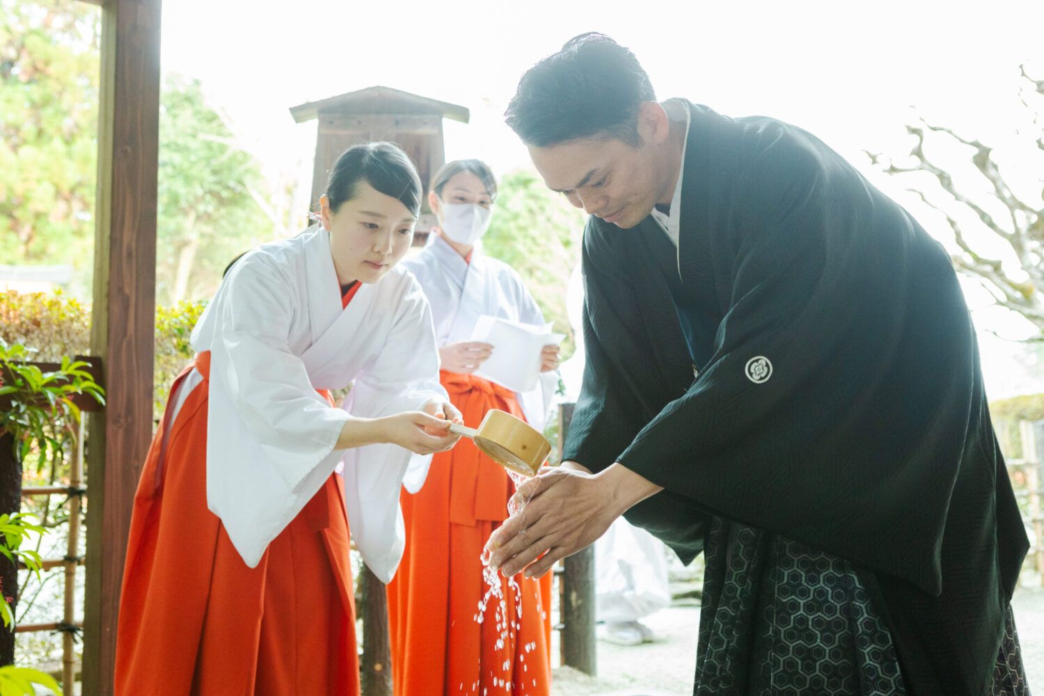 上賀茂神社でご結婚奉告祭前の手水を受ける紋服の新郎