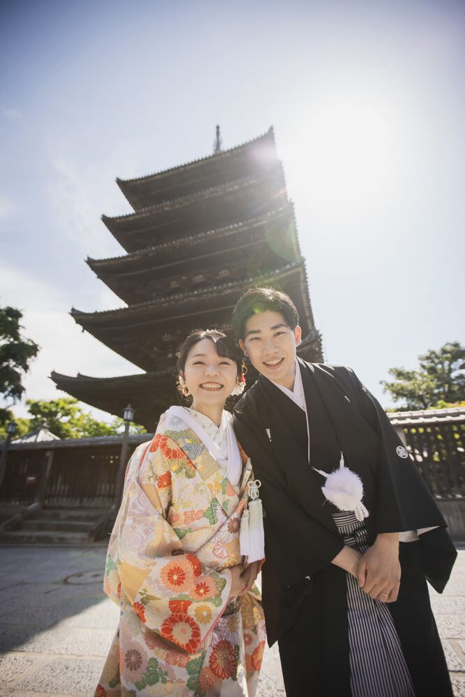 壮大な八坂の塔を背景に色打掛の花嫁と新郎