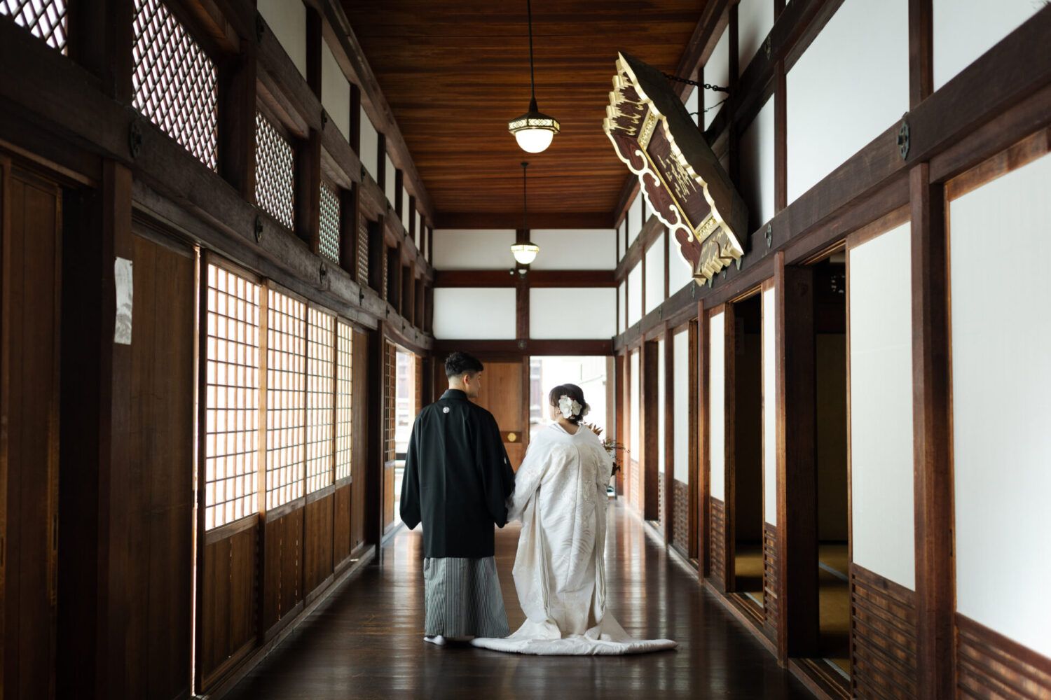 金戒光明寺内の廊下で白無垢の花嫁と新郎の後ろ姿