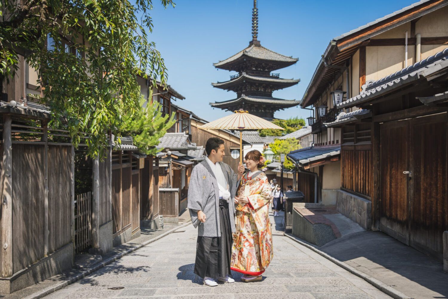 八坂の塔を背景に色打掛の花嫁と新郎
