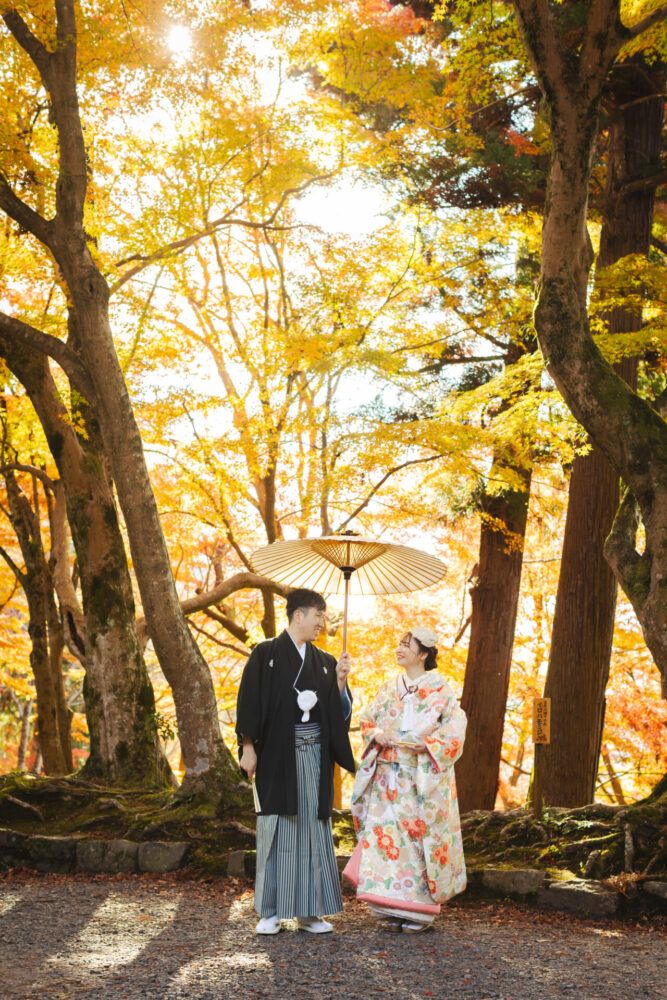 紅葉の毘沙門堂にて。番傘をもつ新郎新婦。