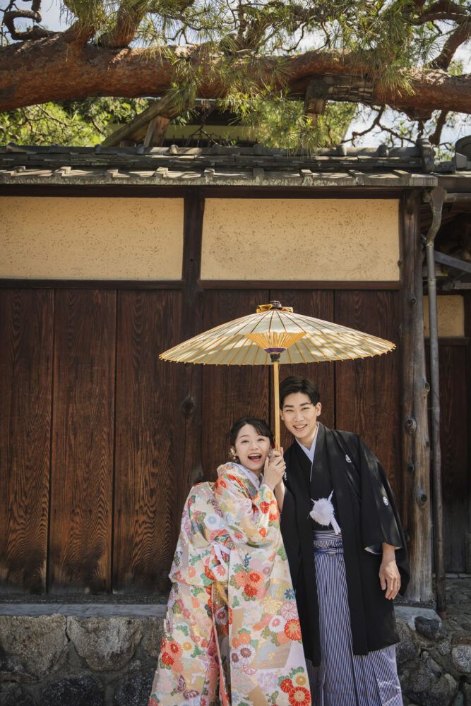 八坂の塔周辺の木塀を背景に色打掛の花嫁と新郎