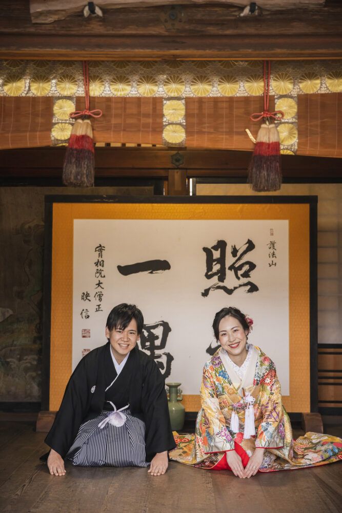 毘沙門堂にて。正座で手をつく新郎新婦。