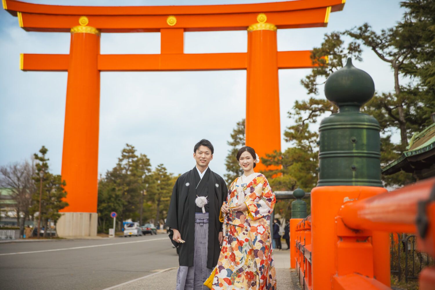 平安神宮の大鳥居を背景に色打掛の花嫁と新郎