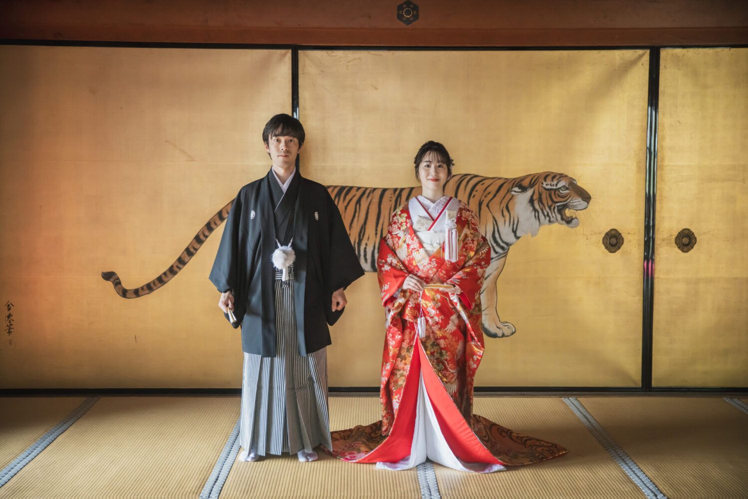 金戒光明寺の黄金の虎の襖前で色打掛の花嫁と新郎