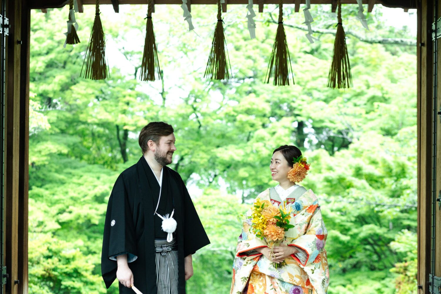 新緑の毘沙門堂にて。ブーケを持つ和装姿の新郎新婦。