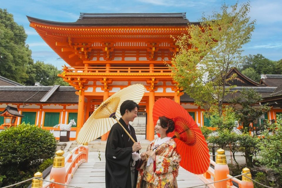 上賀茂神社にて。色打掛姿の花嫁と番傘をもつ新郎新婦。