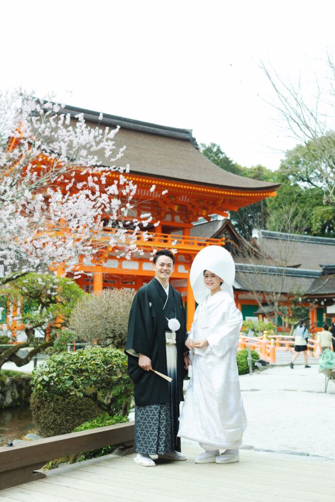 上賀茂神社の桜門前で綿帽子姿の白無垢の花嫁と新郎