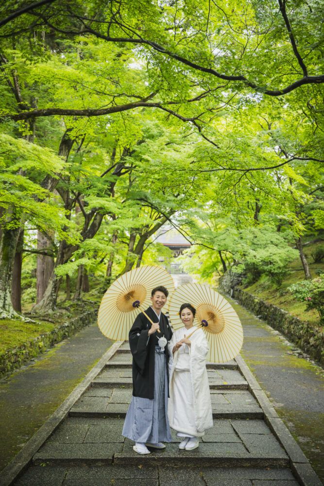 新録の毘沙門堂にて。石畳の階段で番傘姿の新郎新婦。