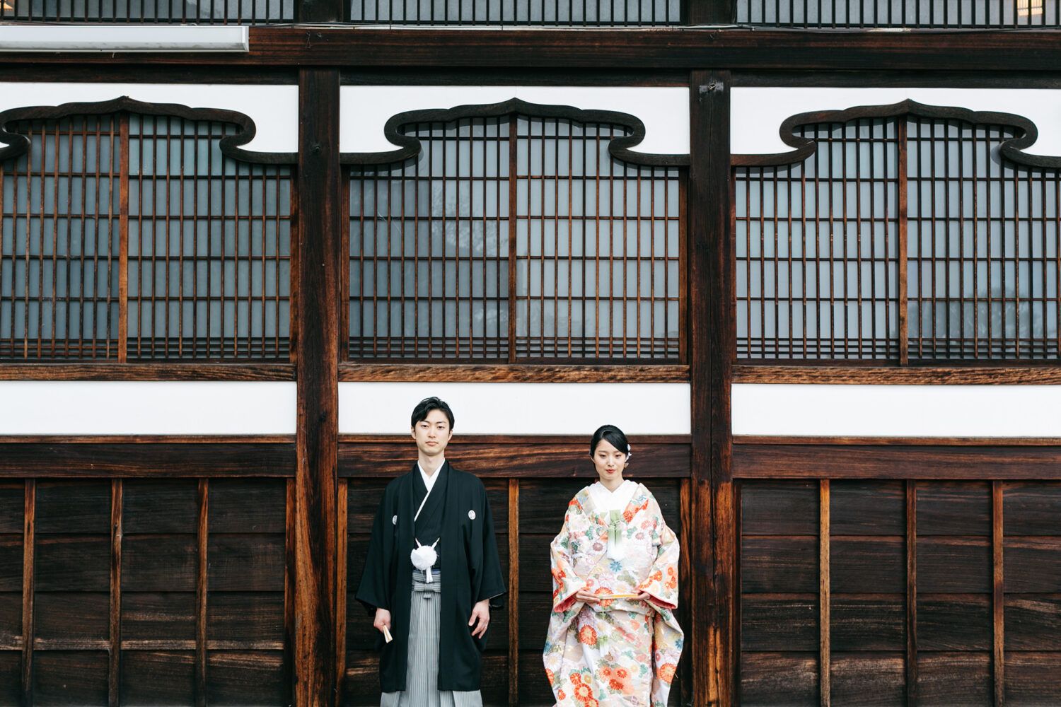 金戒光明寺の本堂外で色打掛の花嫁と新郎