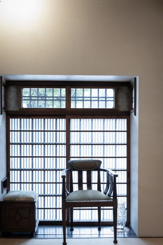 京町家のエントランス。格子窓にアンティークの椅子。