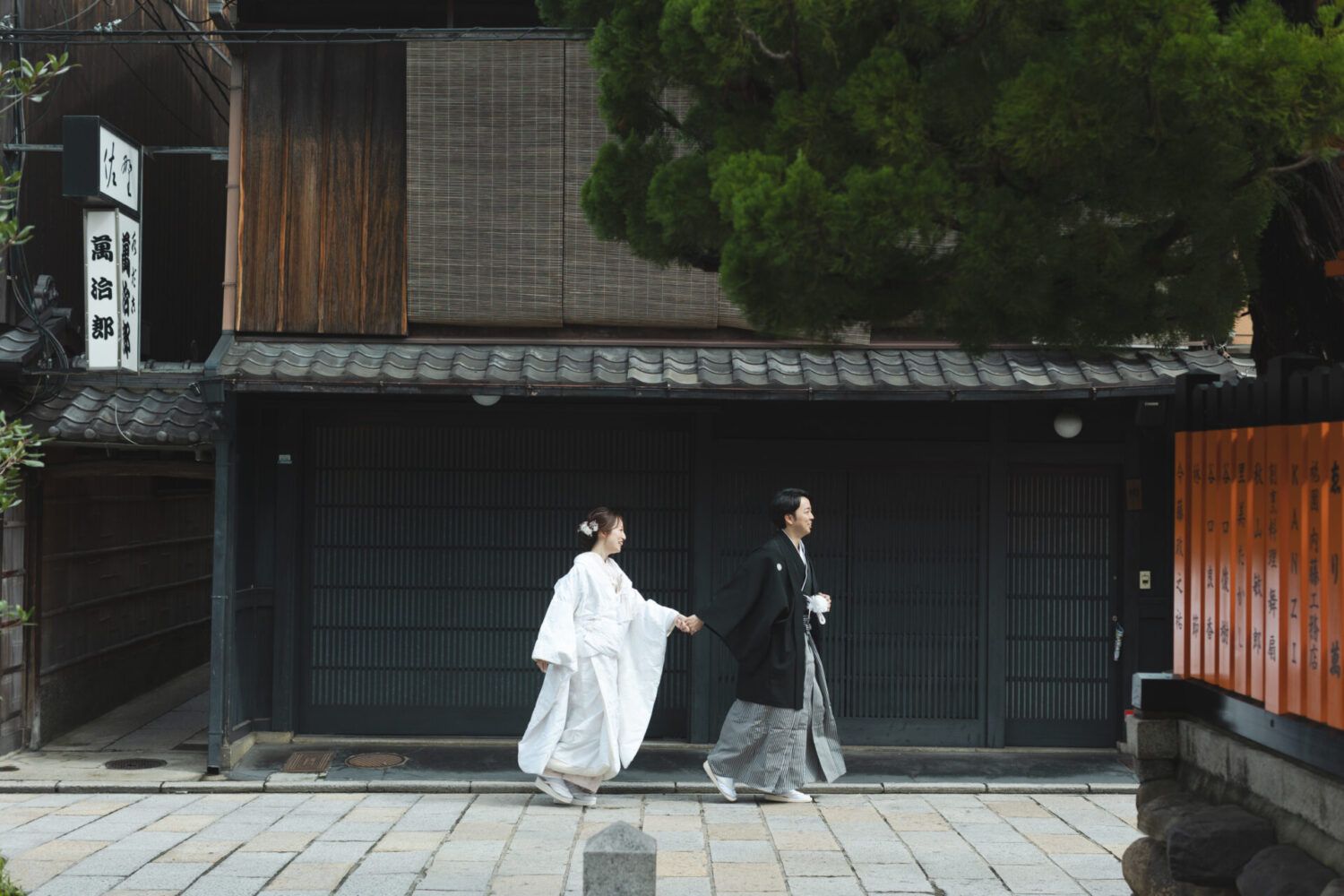 祇園街を白無垢で歩く花嫁と新郎