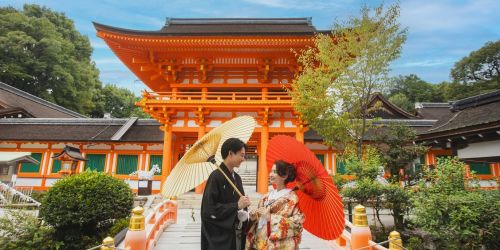 上賀茂神社にて。色打掛姿の花嫁と番傘をもつ新郎新婦。