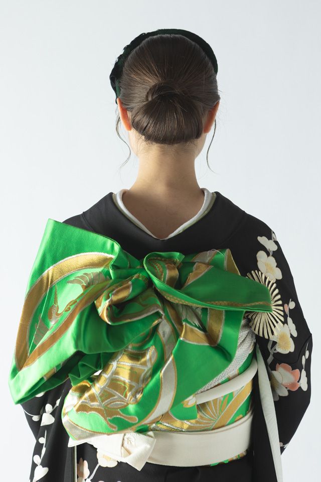 グリーンのトーク帽と梅と松の黒引き振袖のコーディネート