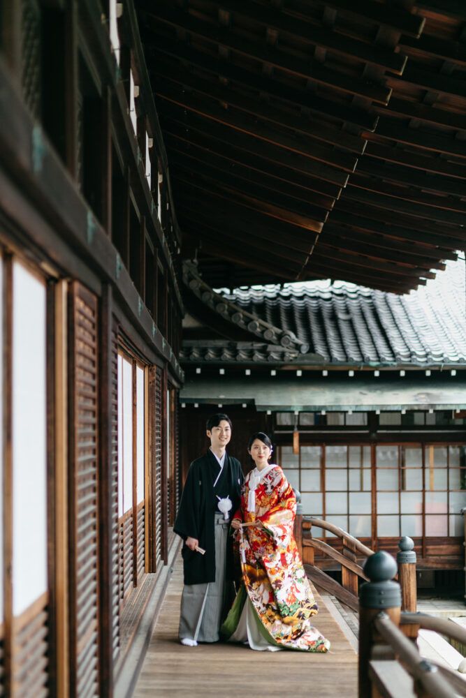 金戒光明寺の本堂廊下で色打掛の花嫁と新郎