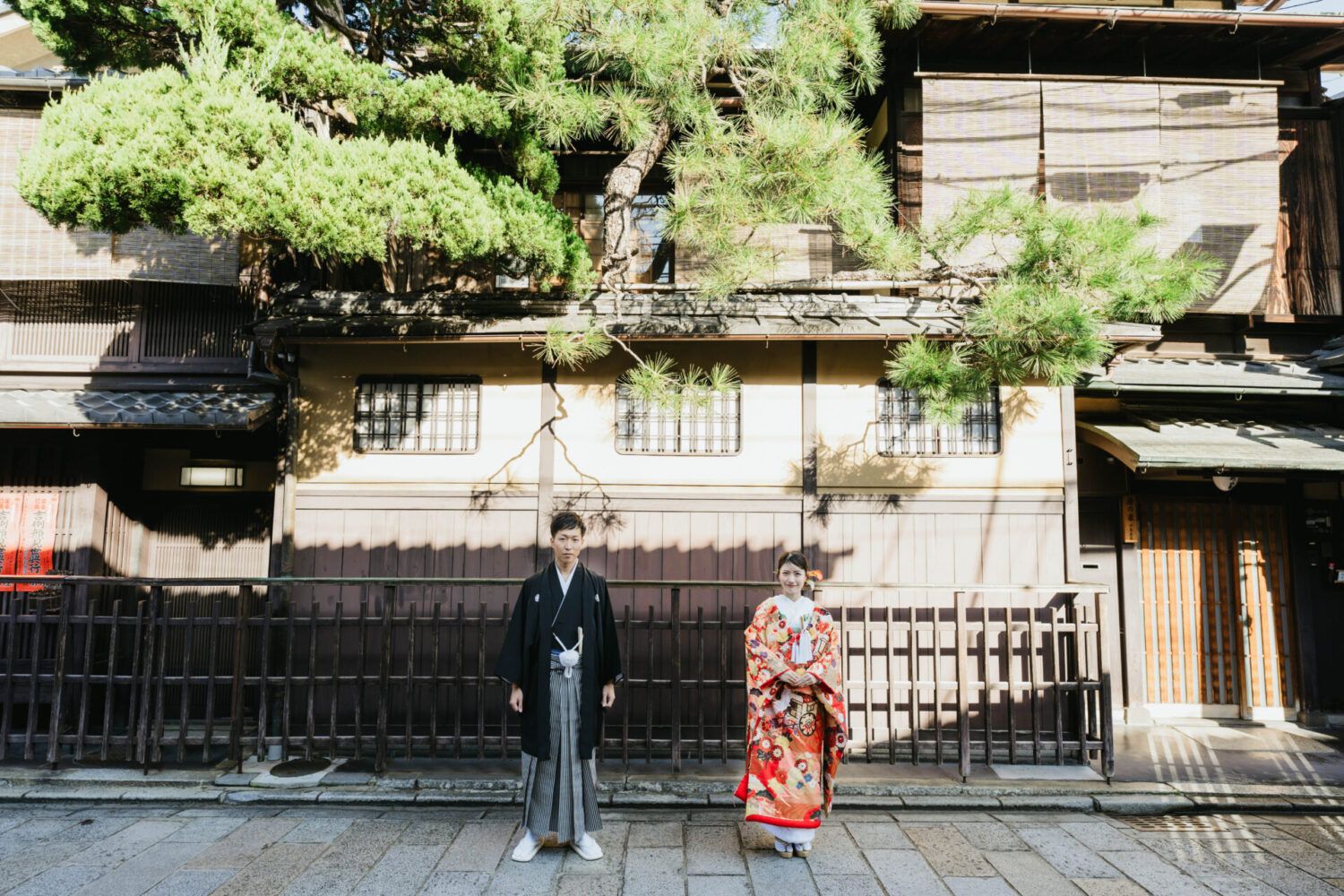 祇園街の石畳で色打掛の花嫁と新郎
