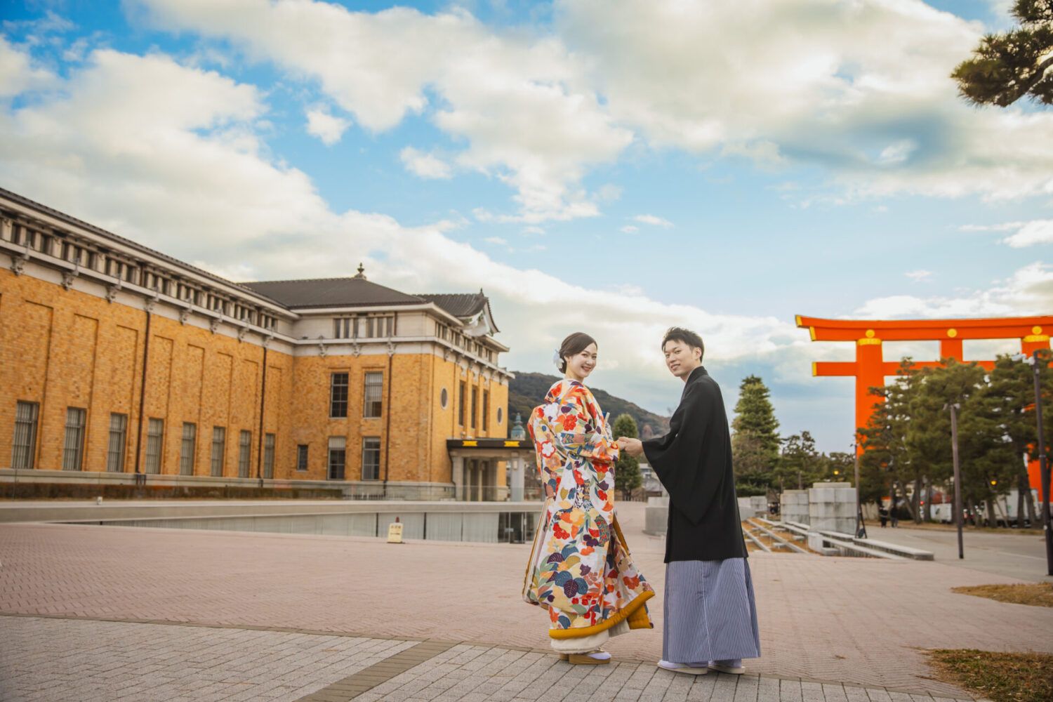 平安神宮周辺の美術館と大鳥居を背景に色打掛の花嫁と新郎