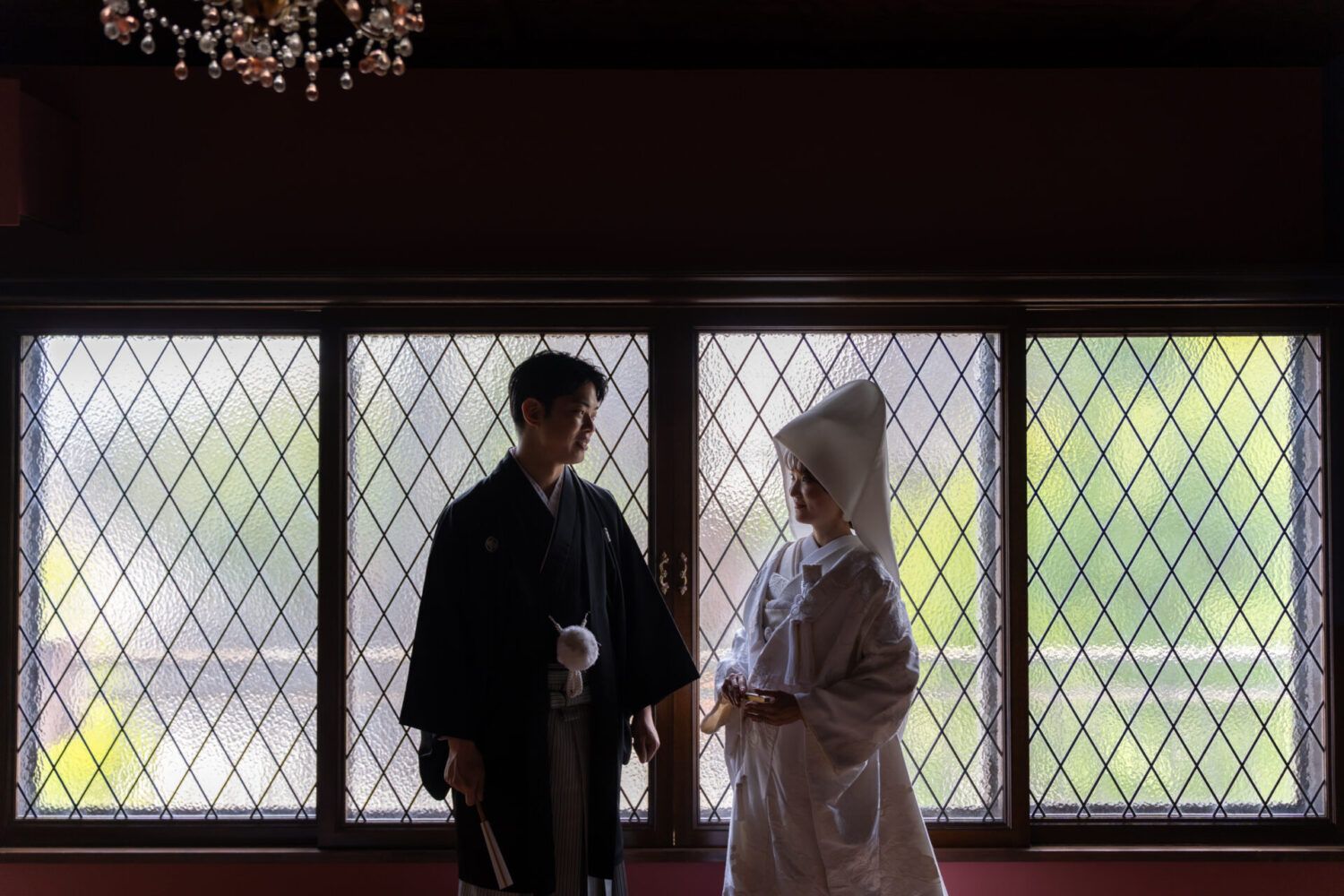 英国アンティークスタジオのステンドグラスを背景に白無垢の花嫁と新郎