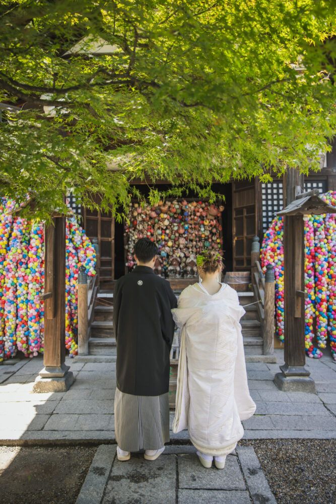 八坂庚申堂で拝む姿の白無垢の花嫁と新郎