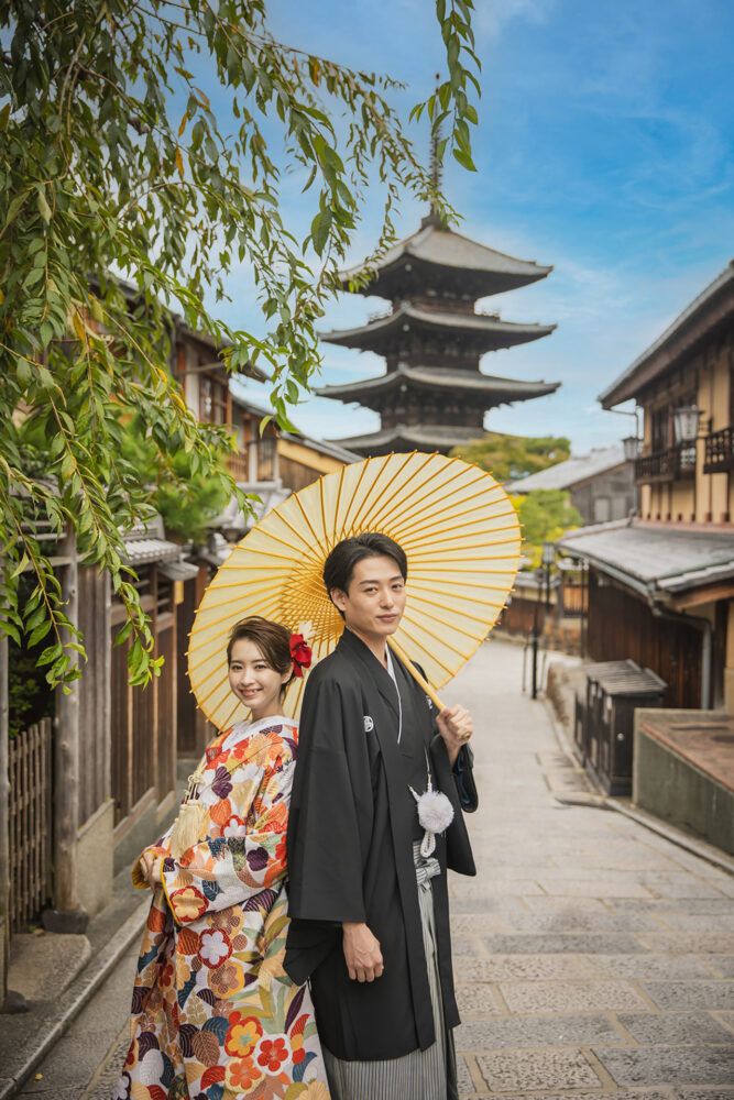 八坂の塔を背景に白い番傘を持って色打掛の花嫁と新郎