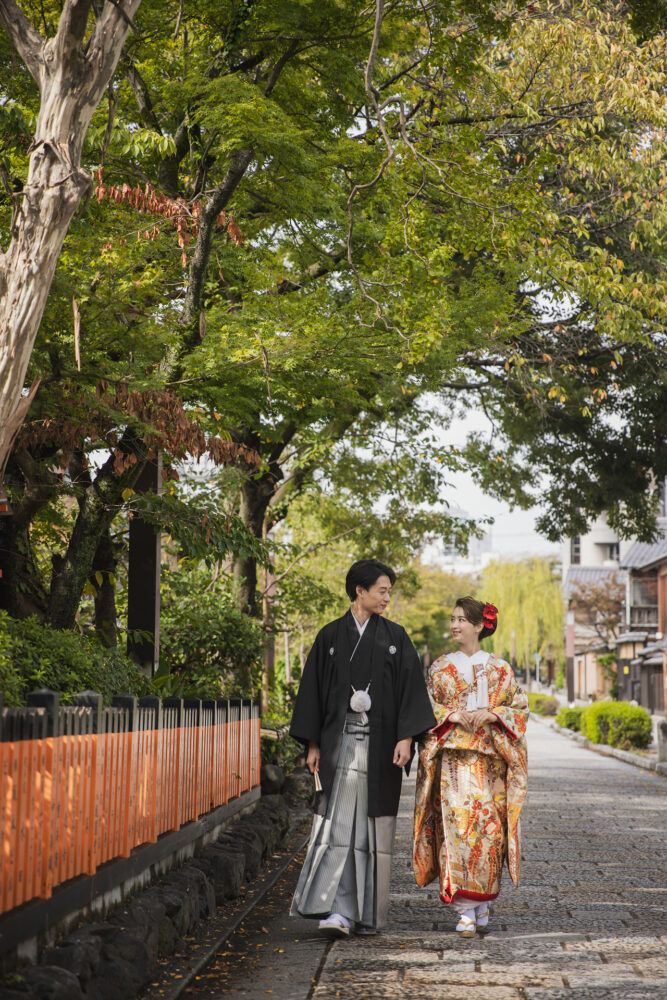 祇園の石畳を歩く色打掛の花嫁と新郎