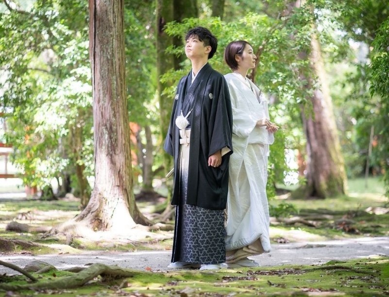 上賀茂神社境内で背中合わせの白無垢の新婦と紋付き袴の新郎