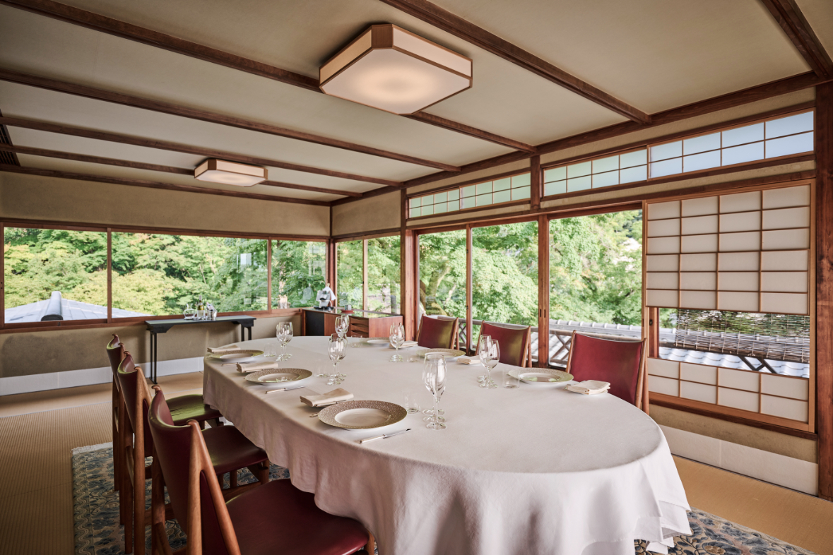 レストランひらまつ 高台寺の広々とした和室。美しい庭園の緑に囲まれ、白のテーブルクロスが映えるエレガントな会食会場です。