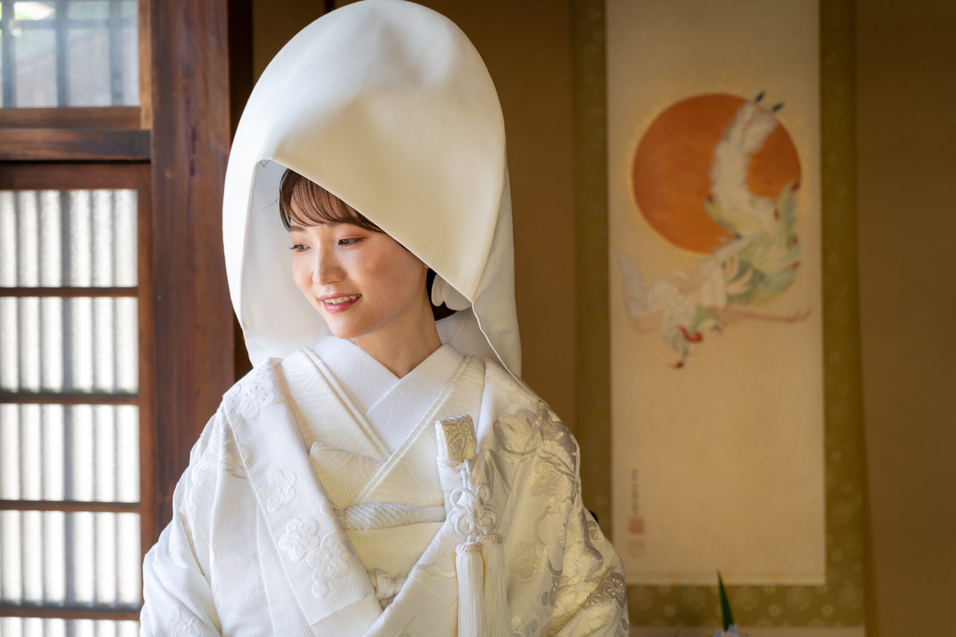 京町家の掛け軸を背景にした綿帽子姿の白無垢