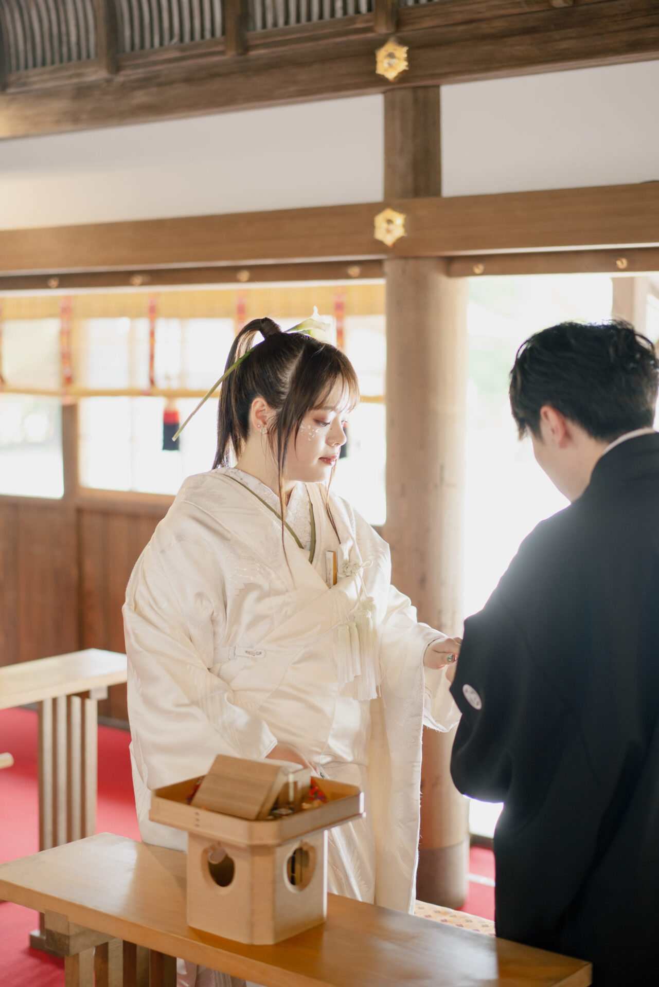 上賀茂神社フォトウェディング
結婚奉告祭
ご希望により、この日は指輪の交換も行われました。
神前での指輪の交換は、おふたりの約束をより深く、厳かに感じさせる特別な時間。
そっと指輪をはめ合う仕草に、ご家族の方々も胸を熱くされていました。