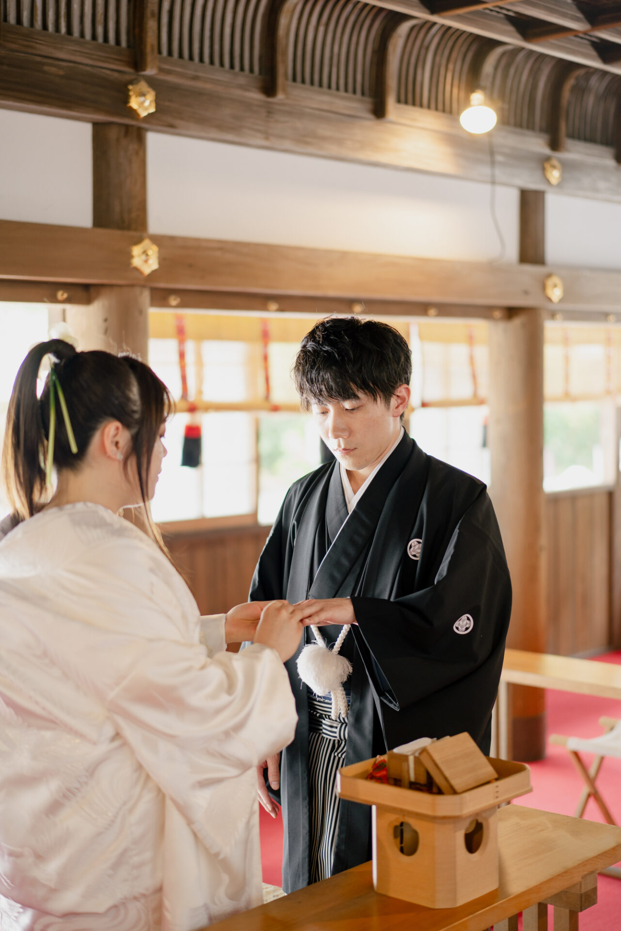 上賀茂神社フォトウェディング
結婚奉告祭
ご希望により、この日は指輪の交換も行われました。
神前での指輪の交換は、おふたりの約束をより深く、厳かに感じさせる特別な時間。
そっと指輪をはめ合う仕草に、ご家族の方々も胸を熱くされていました。