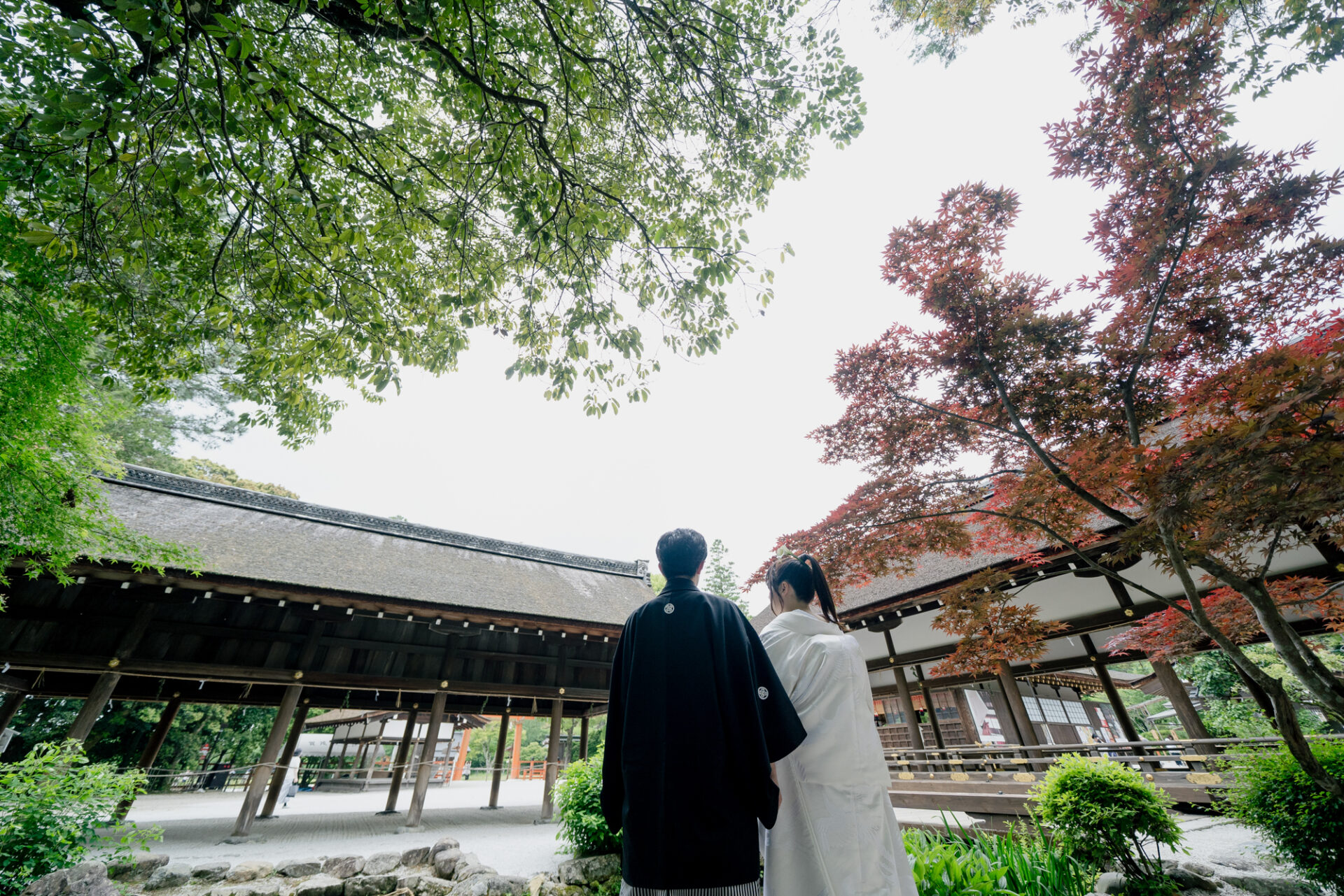 上賀茂神社フォトウェディング
立砂とともに
上賀茂神社といえば、拝殿の手前に置かれた「立砂（たてずな）」。
円錐形に盛られた白砂には、神聖な結界の意味が込められており、古来より邪気を払うと伝えられています。
その立砂の前で手を取り合うお二人の姿には、これからの幸せな未来が自然と重なりました。