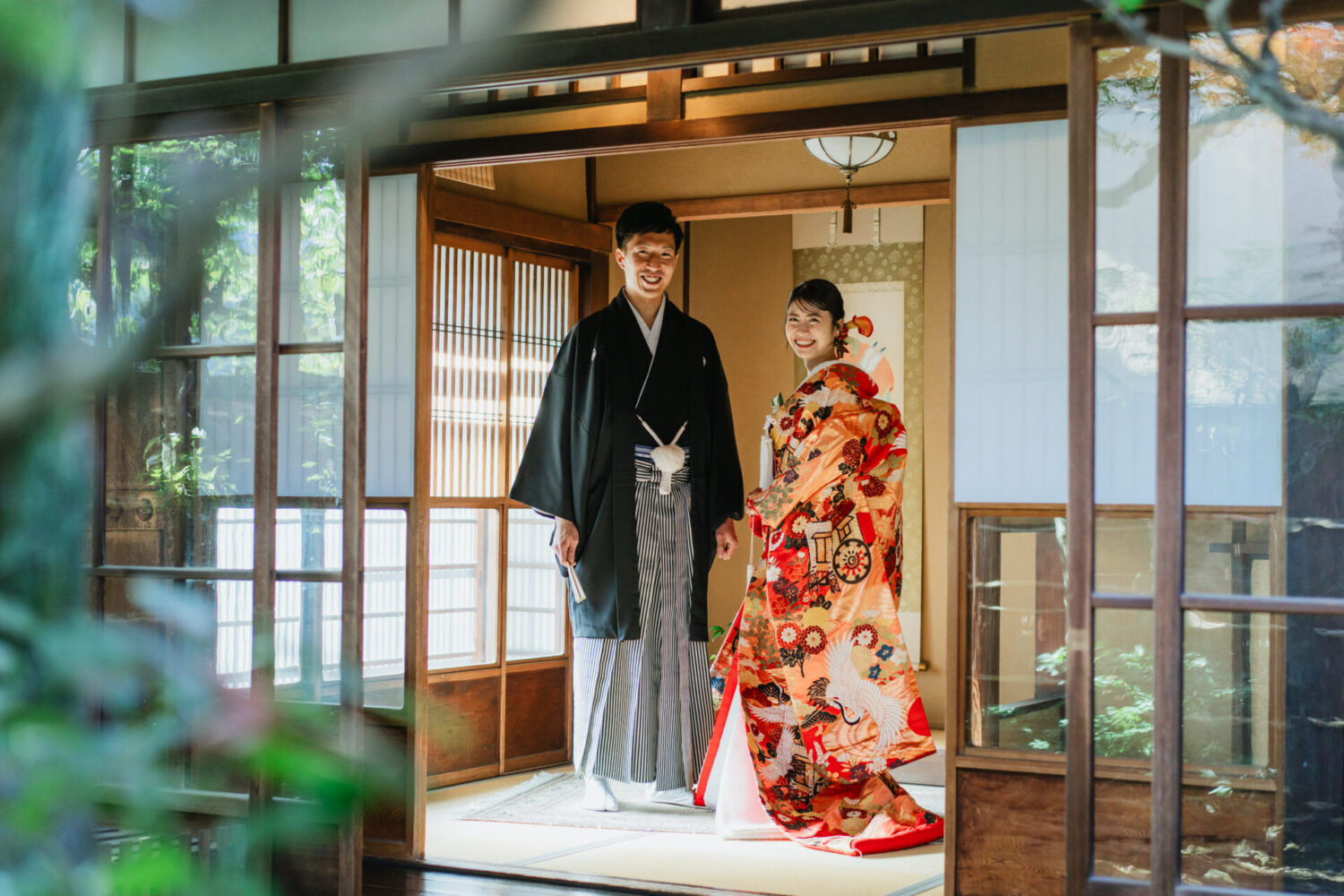 町家の縁側で笑顔を見せる新郎新婦の和装ウェディングフォト