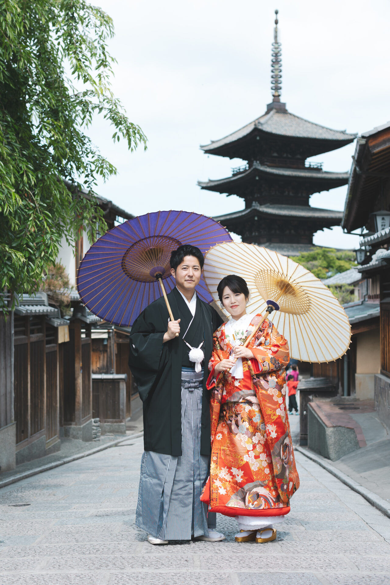 京都フォトウェディング
八坂の塔
五重塔を背景に、そっと寄り添うおふたりの姿は、時代を超えて受け継がれる「日本の美」を体現するよう。
ご新郎様の黒紋付袴とのコントラストも美しく、クラシックで凛とした和装姿がとても印象的でした。