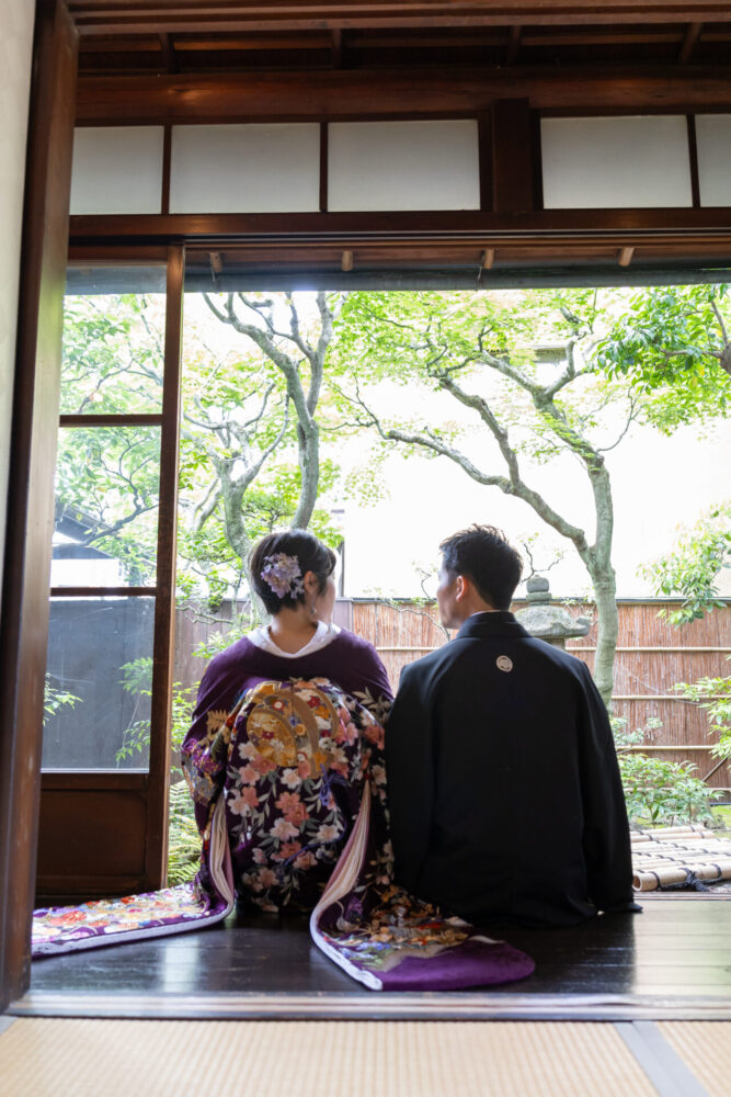 【京町家の庭を望むひととき｜紫の色打掛で和装前撮り】

静かな京町家の縁側。
新婦様の後ろ姿は、気品と華やかさを兼ね備えた紫の色打掛。
縁側に佇み、季節の移ろいを感じながらそっとお庭を見つめるその姿は、まるで時を超えた一場面のよう。

京都町家寫眞館ならではの、趣ある和の空間と緑豊かな庭が、花嫁姿をより一層引き立ててくれます。

しっとりと美しい、京都らしさあふれる和装フォトウェディングとなりました。