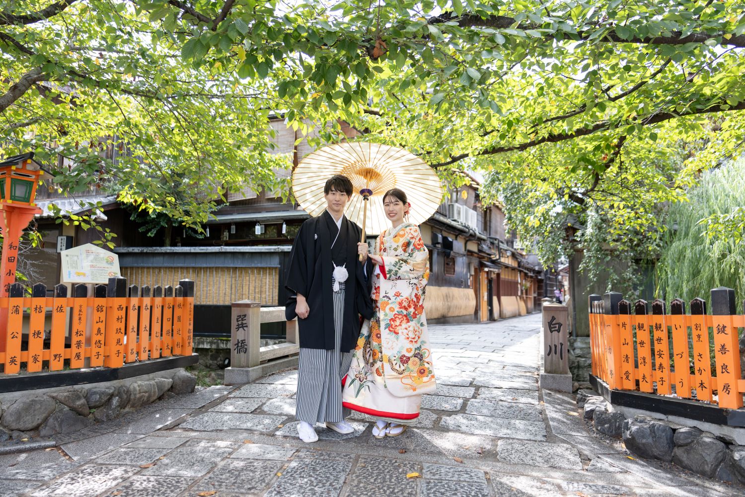 京都祇園での前撮り｜番傘を持つ色打掛の花嫁と新郎