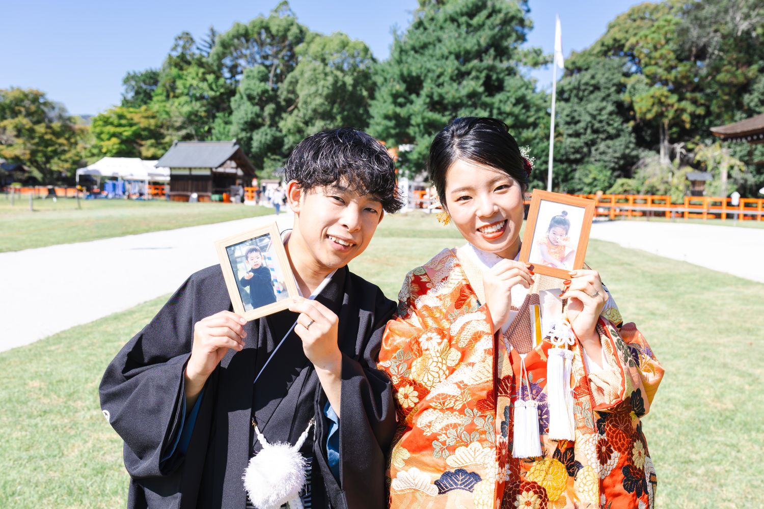 上賀茂神社のフォトウェディング。幼少期の写真を手に、笑顔の新郎新婦。