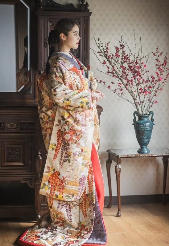 京町家のアンティーク家具の横に佇む、白地に紅葉柄の色打掛を着た花嫁の全身写真