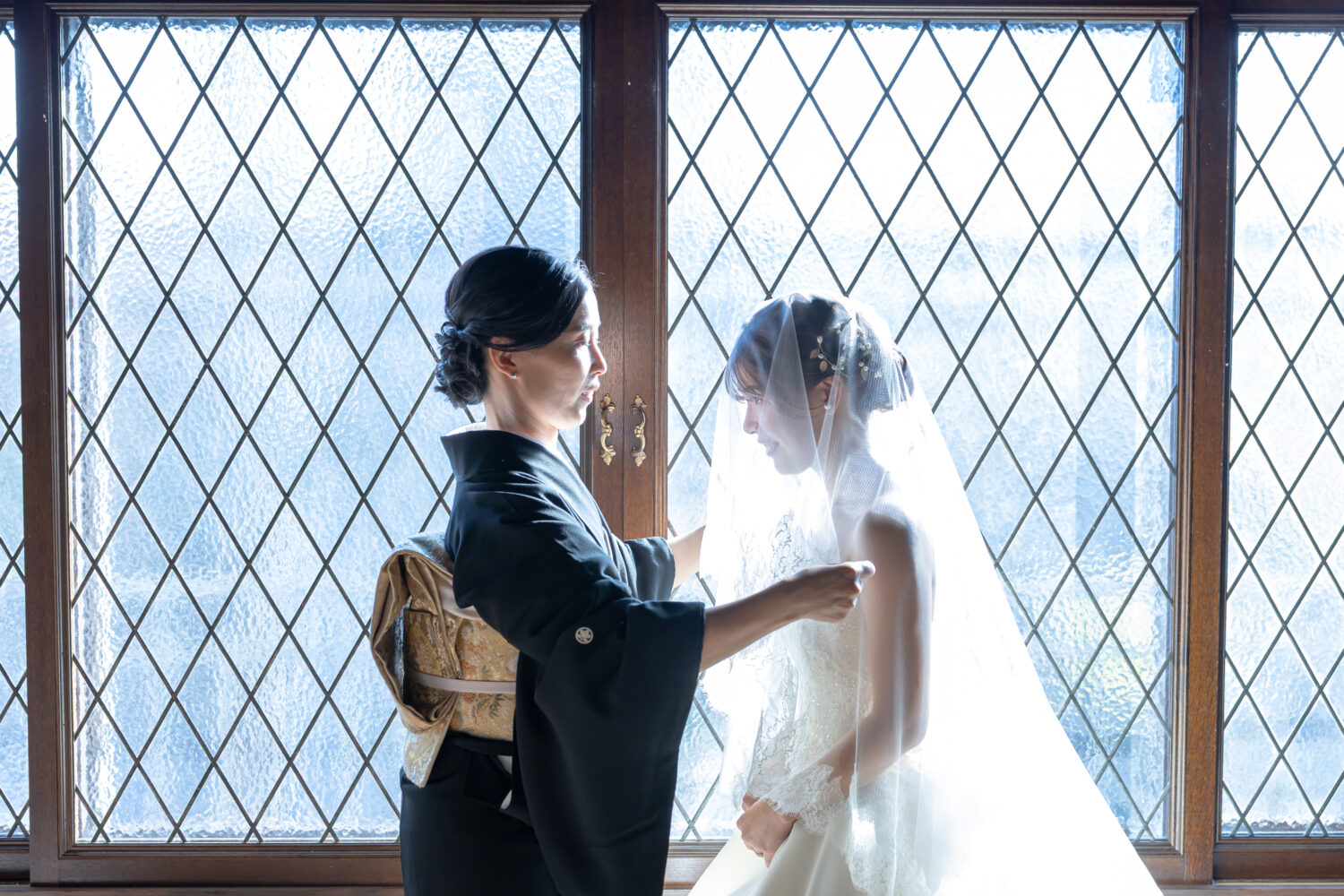 ベールを上げる母と新婦