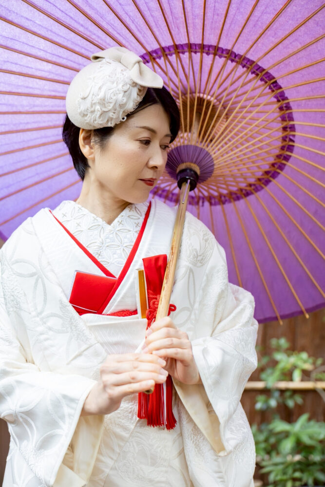 トーク帽をあしらったショートヘアの白無垢姿の花嫁。番傘を差している
