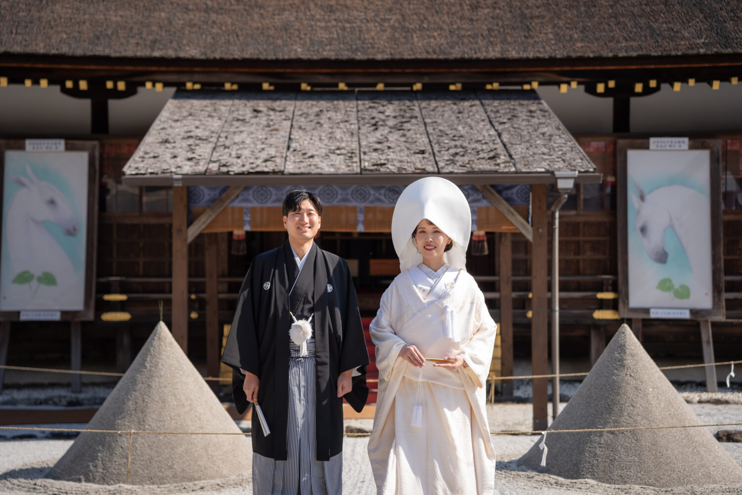 上賀茂神社本殿前でほほ笑む白無垢の新婦と紋付き袴の新郎