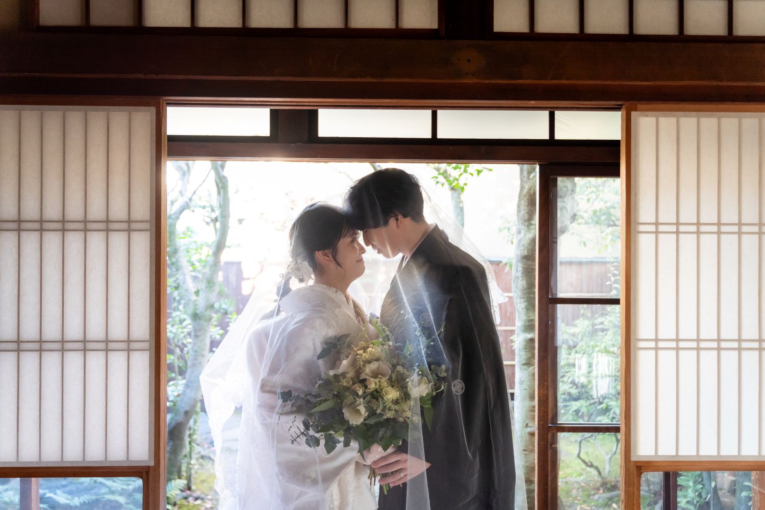 京町家スタジオの和室で、寄り添う新郎新婦のベールショット(白無垢×ベール)