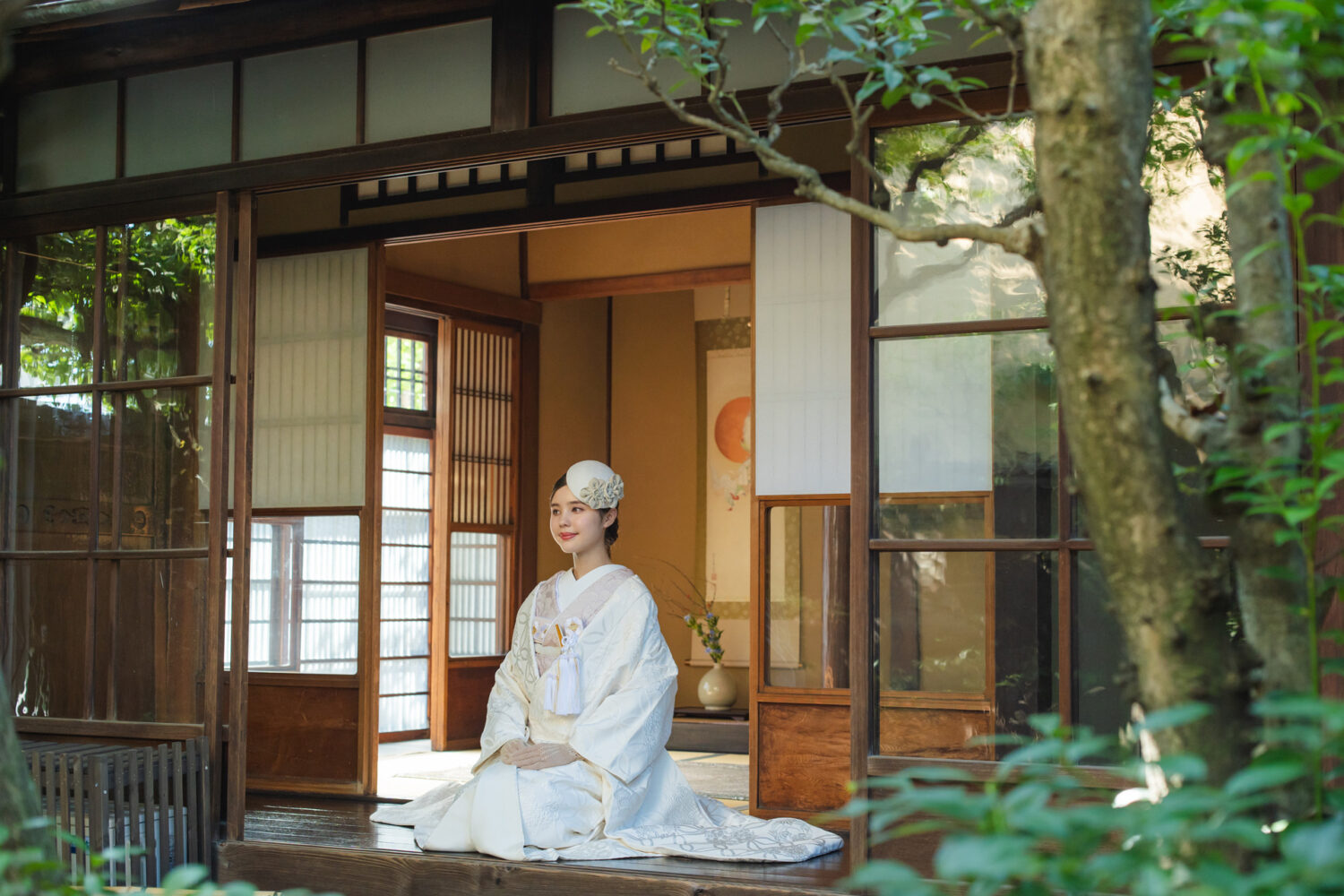 町家の縁側に座る白無垢姿の花嫁とヘッドドレスの和装スタイル