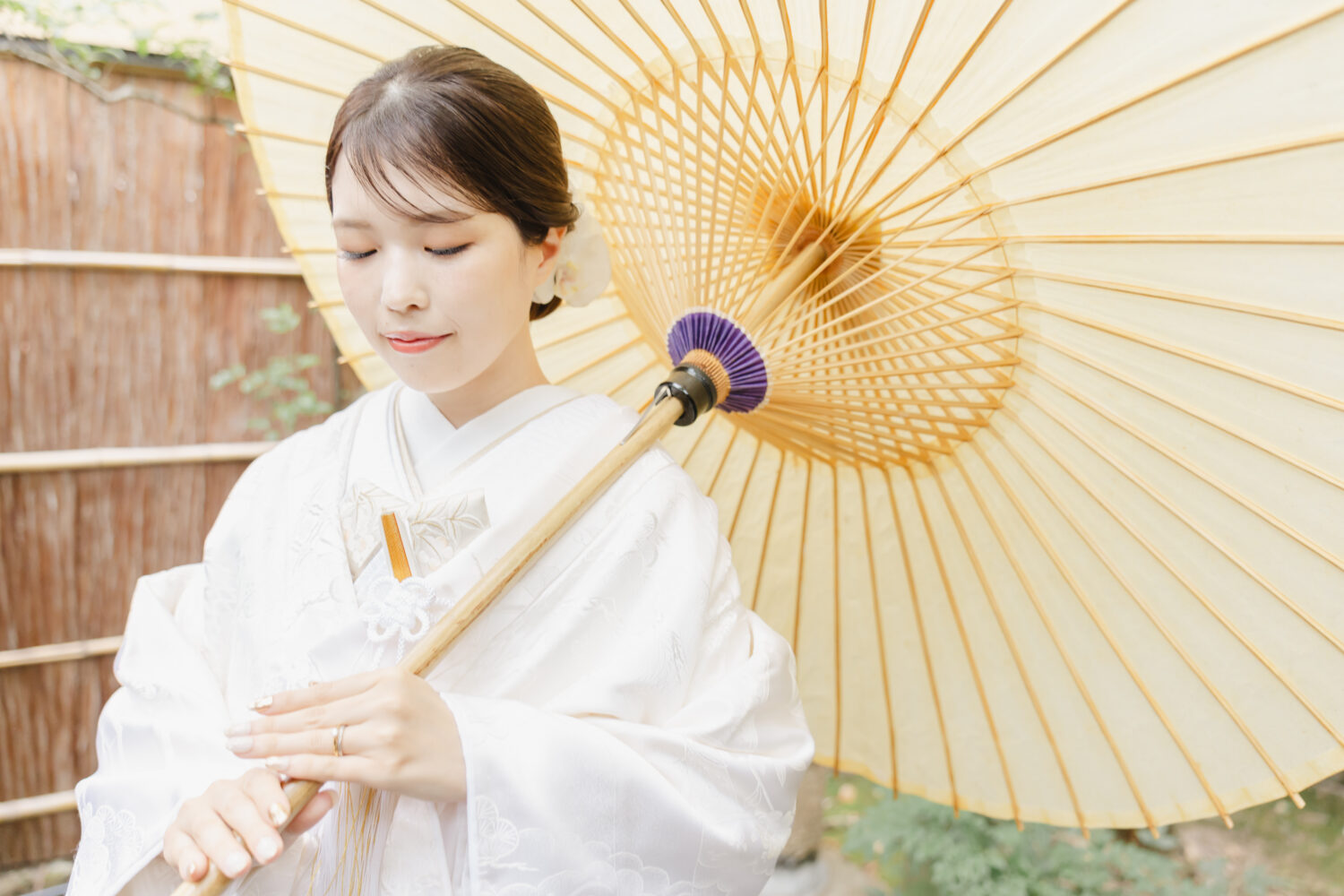 京町家の坪庭で白の和傘をさし、白無垢に洋髪を合わせた花嫁のソロポートレート